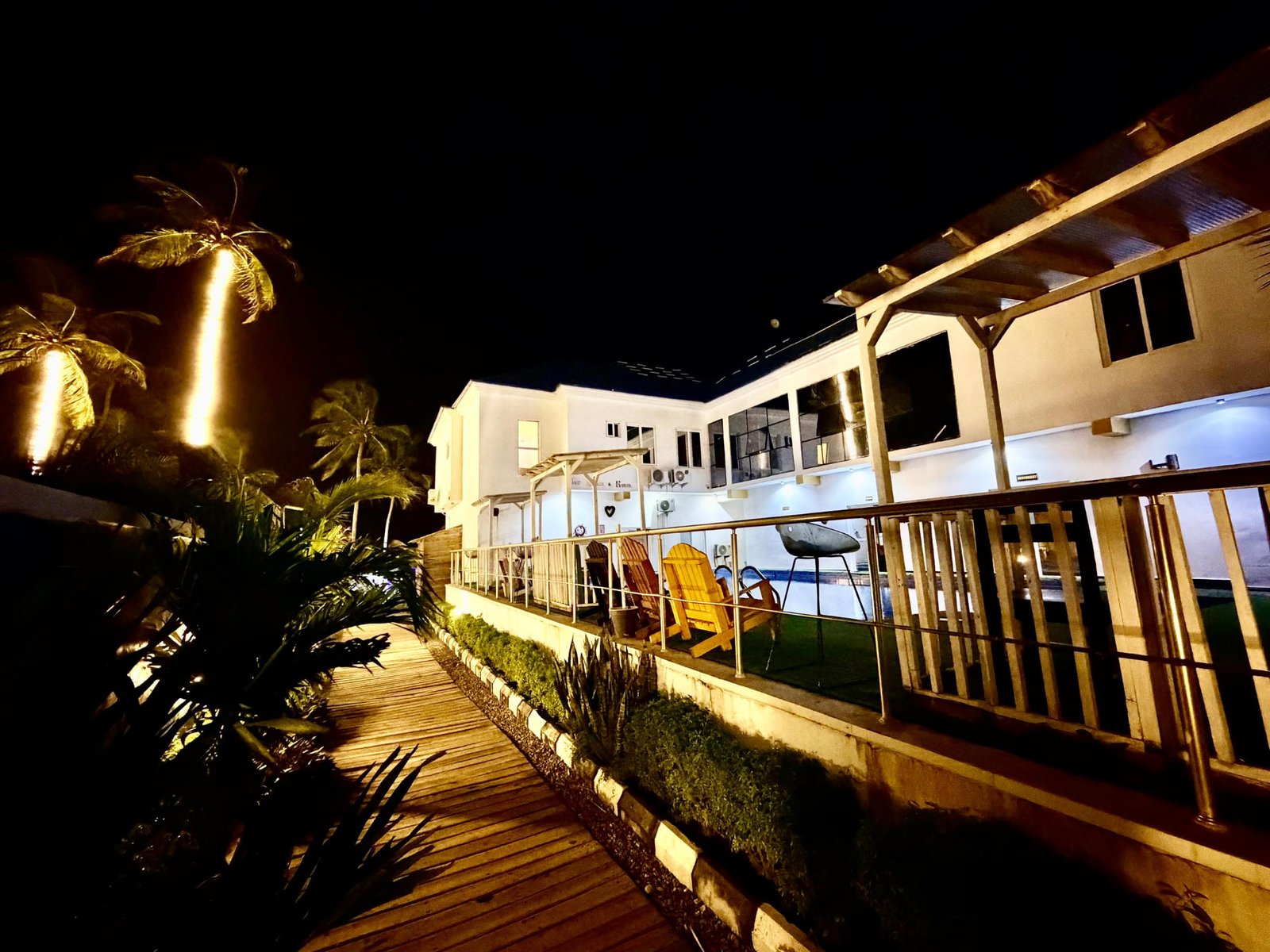 Lit boardwalk and pool deck at Jet Beach Club at night