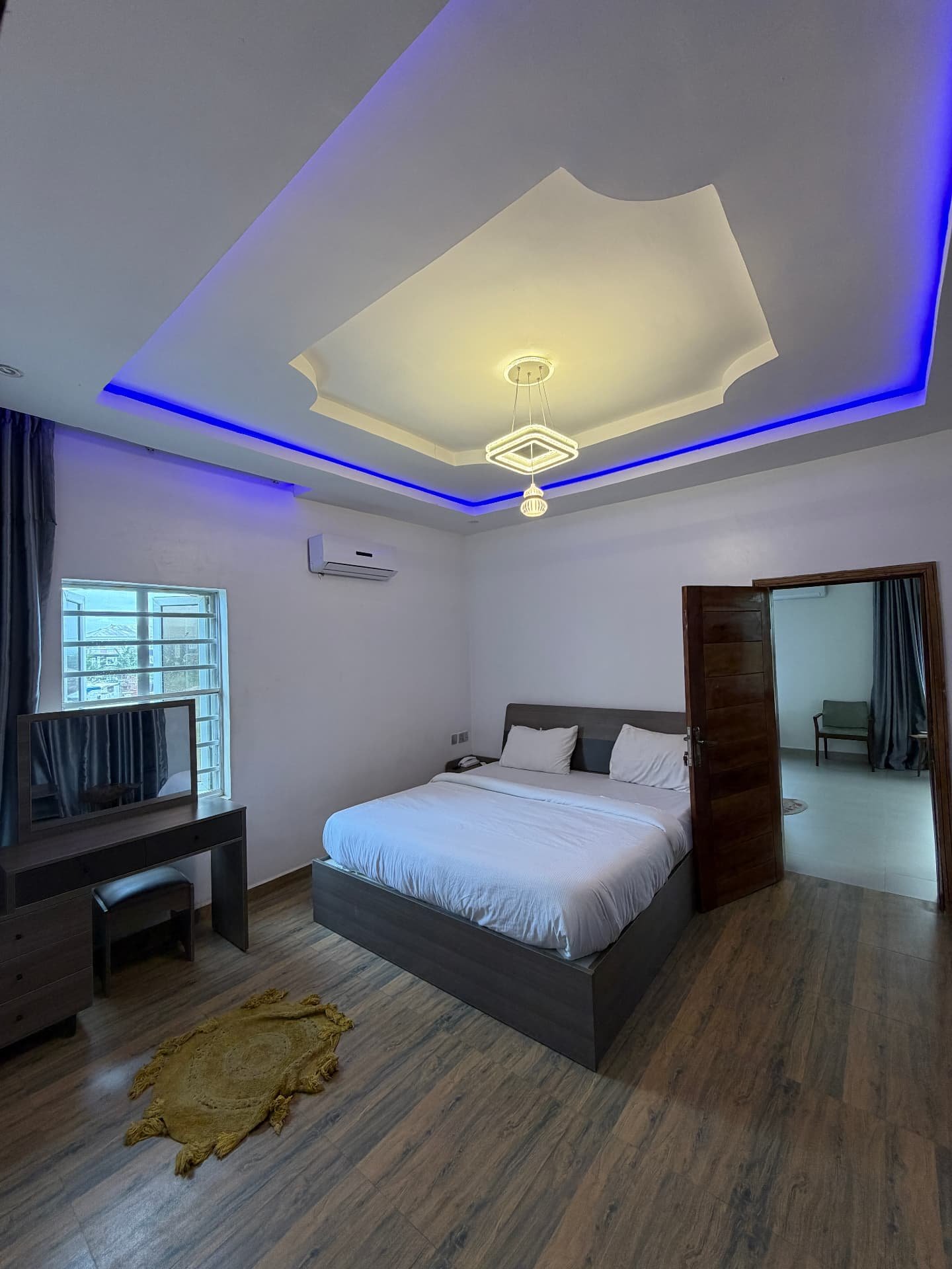 Open-plan living room with wood-slatted feature wall in the 2 Bed pool apartment